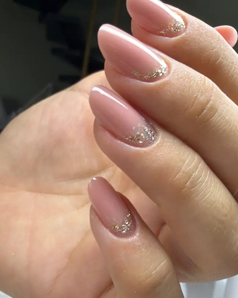 Uñas nude con destellos dorados en la base